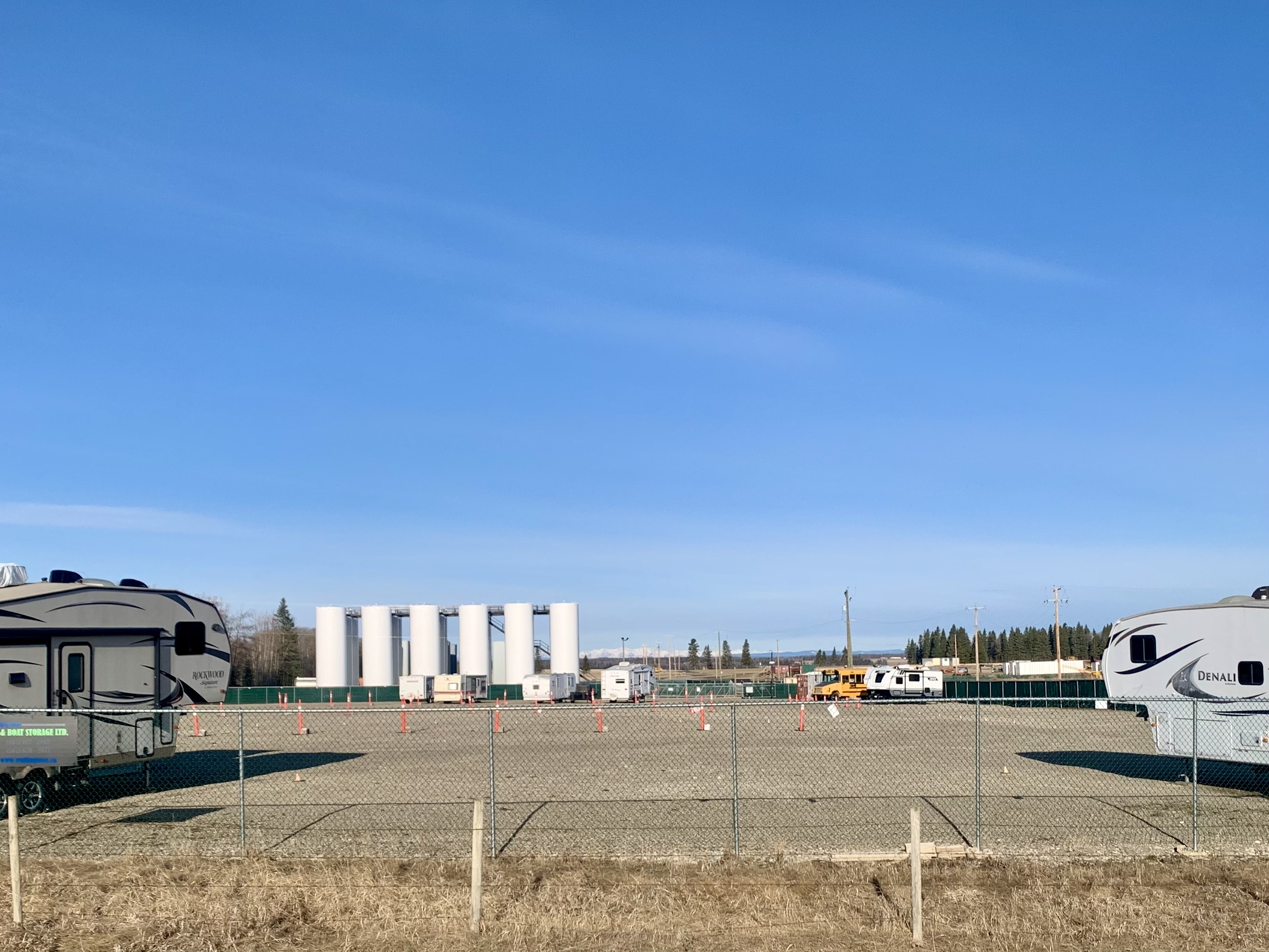 View of Trailing West RV and Boat Storage lot with gravel parking stalls and secure perimeter fencing near Sundre, Olds and Cochrane, Alberta